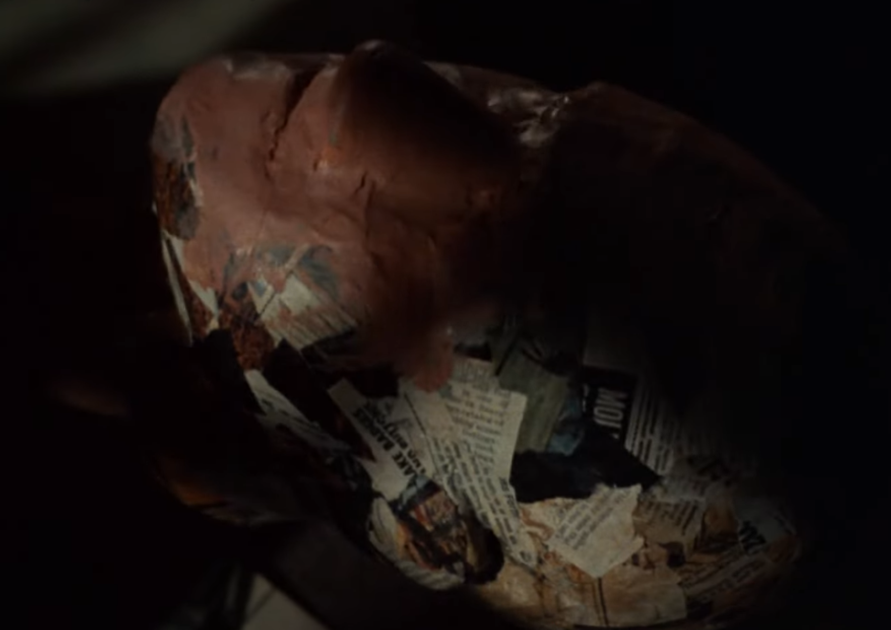 Clint Eastwood's character making a fake human head from newspapers and pulp.