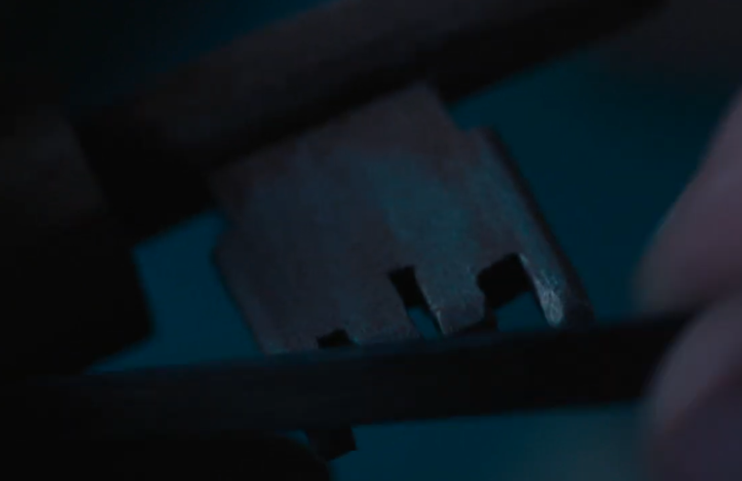 Character of Daniel Radcliffe making a wooden replica of a key in prison